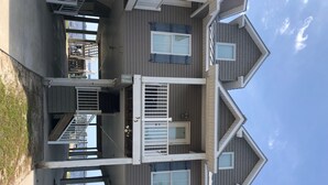 A two-story building with a balcony and a covered outdoor area. - Bayfront Condo with Boat Slip (Panacea)