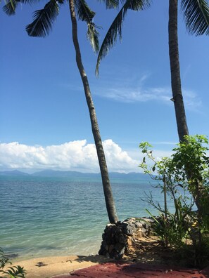 Rannalla, aurinkotuoleja, rantapyyhkeitä