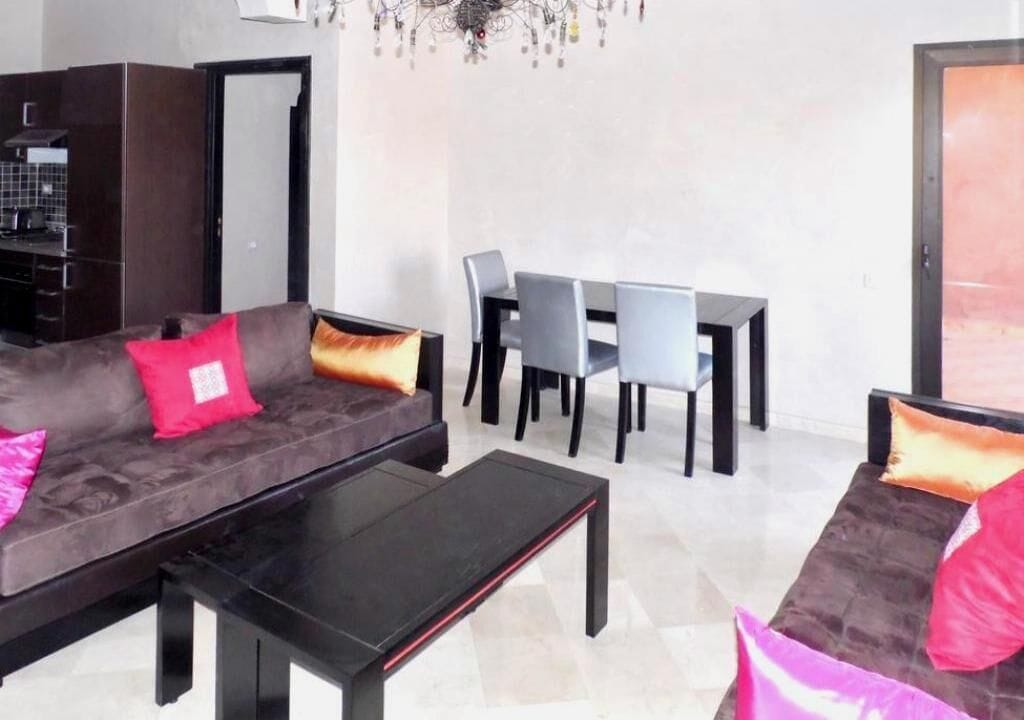 Ein modernes Wohnzimmer mit einer Couch, einem Couchtisch und einem Esstisch mit Stühlen.