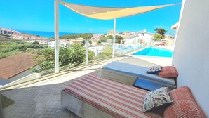 A balcony with a view of a swimming pool and houses.