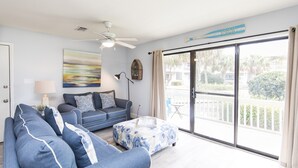 A living room with a sofa, a coffee table, and a ceiling fan. - Modern Ground Floor Condo w/ 2 Pools, Beach Access + Free Attraction Tickets! (Santa Rosa Beach)
