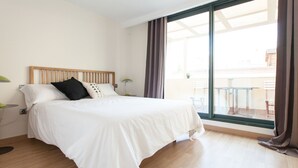 A modern hotel room with a large bed, wooden headboard, and a view of the outside balcony. - Albareda 5 - One Bedroom Apartment, Sleeps 4 (Sevilla)