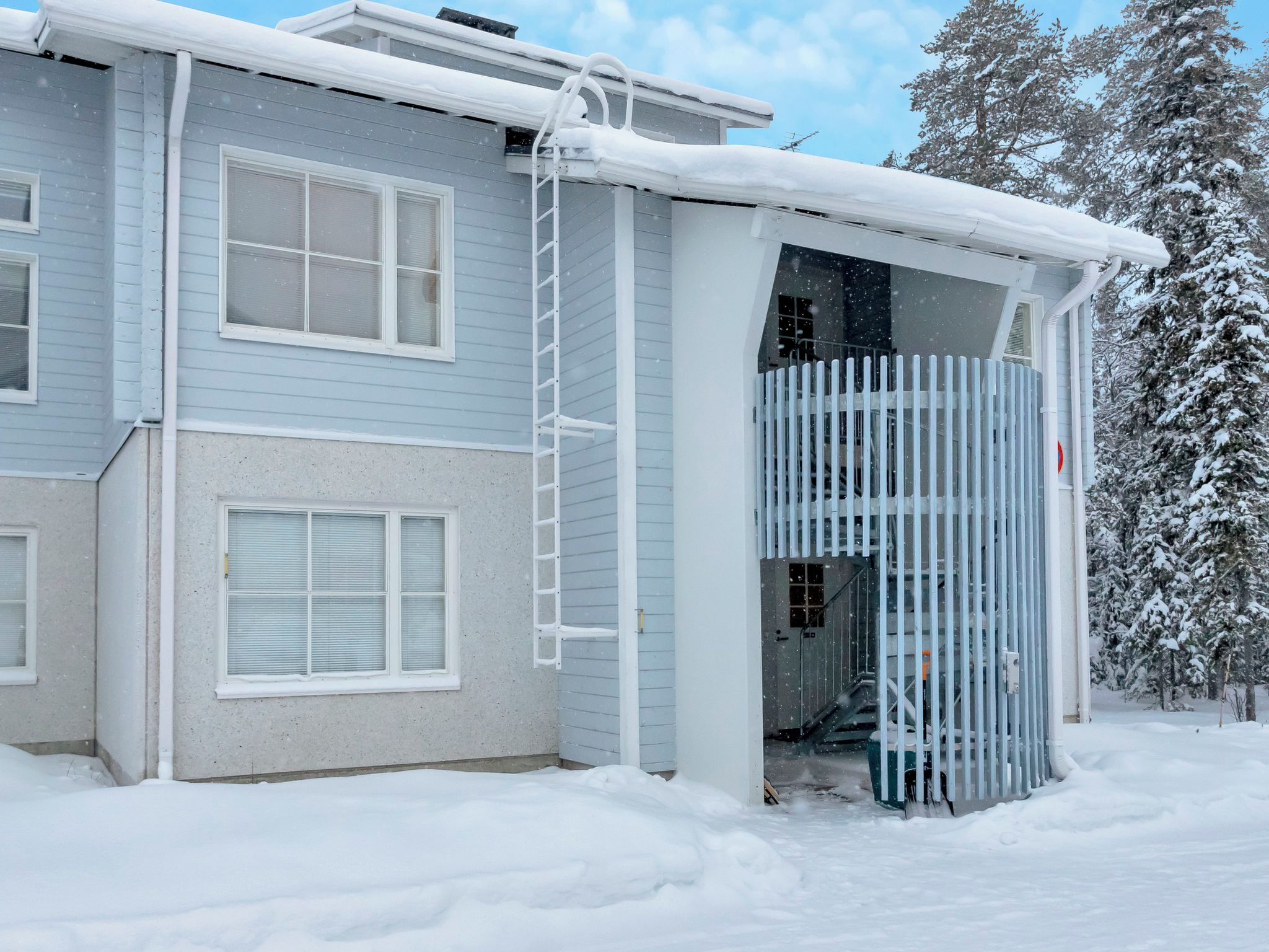 A two-story house with a covered entryway and a visible staircase leading to the upper floor.