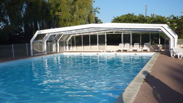 A swimming pool with a covered area and lounge chairs. - wooden chalet in the gardens of St Pierre (Saint-Pierre-D'oléron)