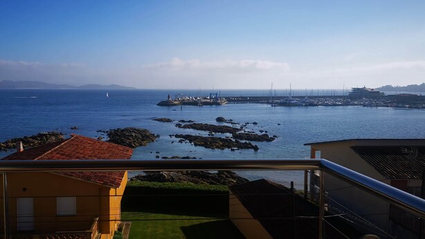 A coastal view with a marina, rocky outcrops, and distant mountains. - Housing with sea views. (Sanxenxo)