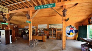 Un intérieur rustique en bois, agrémenté d’enseignes indiquant « City of Portland », « Market », « Fairness St » et « Fish St ».