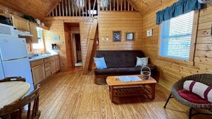 A cozy cabin interior with a kitchen, dining area, and living room. - Ravine- Firepit, Pet Friendly, Cozy Cabin, WIFI, Pond, Gas Fireplace, off Blue Ridge Parkway (Laurel Springs)