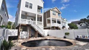 A residential property with a two-story house, a covered patio, and a swimming pool. - Barefoot 'N Salty - Walk to Beach in Surfside Beach (Surfside Beach)