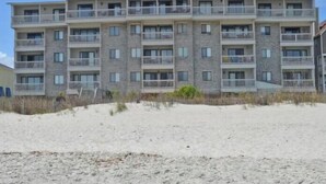 A multi-story beachfront building with balconies, likely a hotel or apartment complex. - Surfwatch III 205 - Oceanfront Condominium in Surfside Beach (Surfside Beach)