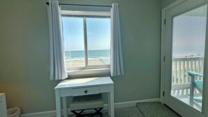 A room with a desk, a view of the beach, and a sliding glass door. - Surfwatch III 205 - Oceanfront Condominium in Surfside Beach (Surfside Beach)