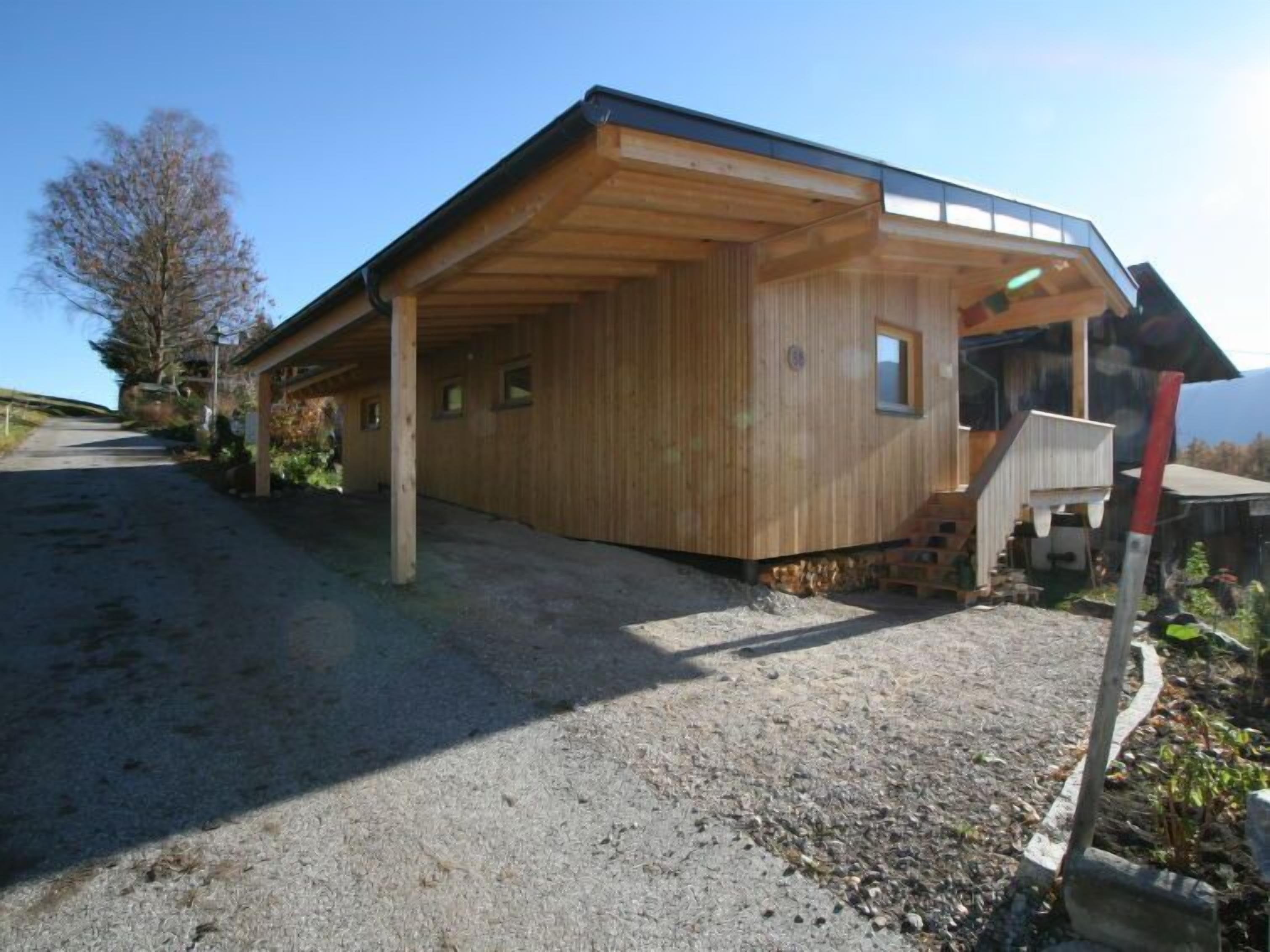 A wooden building with a covered porch and a gravel driveway.