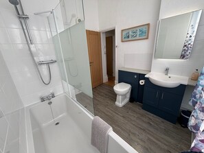 Bañera, secador de pelo, toallas y jabón
