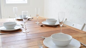 A dining table set with white bowls, plates, and wine glasses, arranged neatly on a wooden table. - Great location, close to Ventnor beach and town. Perfect for families. (Isle of Wight)