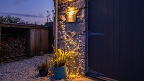 Un bâtiment en pierre avec une porte en bois et une enseigne sur laquelle on peut lire : « L’ancienne écurie ».