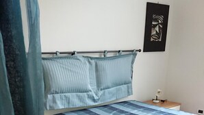Une chambre à coucher avec un lit, une table de chevet et un tableau accroché au mur.