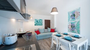Una sala de estar moderna con sofá, mesa de comedor y obras de arte.