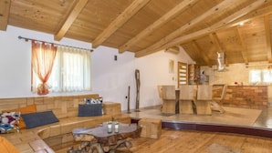 Un interior de madera con sofá, una mesa de centro y una zona de comedor.