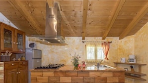 Una cocina con armarios de madera, una isla central y una campana de acero inoxidable.