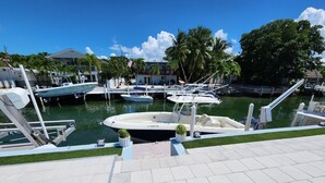 A marina with several boats docked, a clear sky, and a well-maintained walkway. - Yellowtail Getaway 3 bedrooms,4 beds,3 bath,boat dock,ice maker and heated pool (Marathon)
