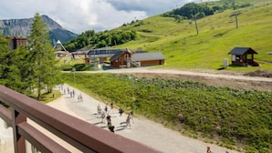 Un village de montagne aux bâtiments traditionnels en bois, doté d’un télésiège et offrant un ciel dégagé.
