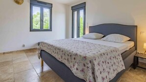 A bedroom with a bed, two windows, a ceiling light, and a nightstand. - L'Oliveraie by Interhome (Pernes les Fontaines)