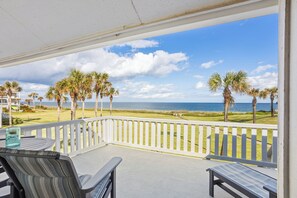 Enjoy the unobstructed ocean view from this balcony with seating areas and a lawn below.