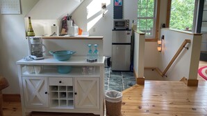 Eine Küche mit Kaffeemaschine, einer Schüssel und einem Kühlschrank.