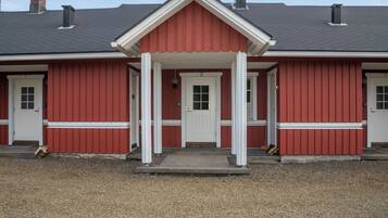 A red building with a white entrance and two chimneys.