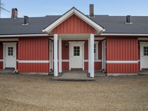 Ein rotes Gebäude mit weißem Eingang und zwei Schornsteinen.