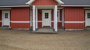 Un edificio rosso con un portico bianco e due camini.