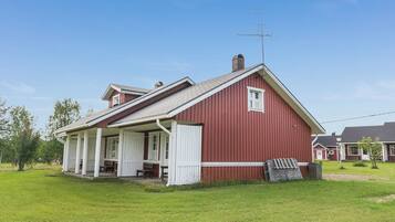 A red barn with a porch, a chimney, and a weather vane.