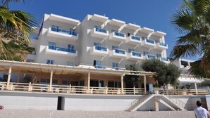 A multi-story hotel with balconies, a covered outdoor area, and a staircase leading to the entrance. - Hotel Coral (Vlorë)