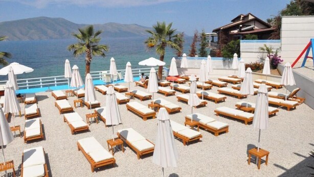 A beachside lounge with sunbeds and umbrellas, overlooking a pool and the sea. - Hotel Coral (Vlorë)
