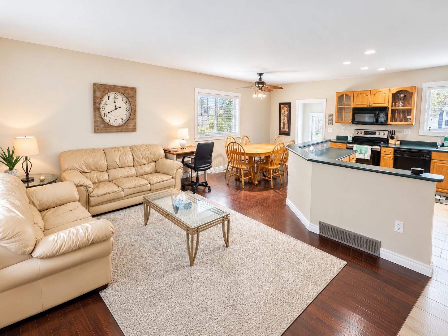 A living room with a sofa, coffee table, and a dining area with chairs.