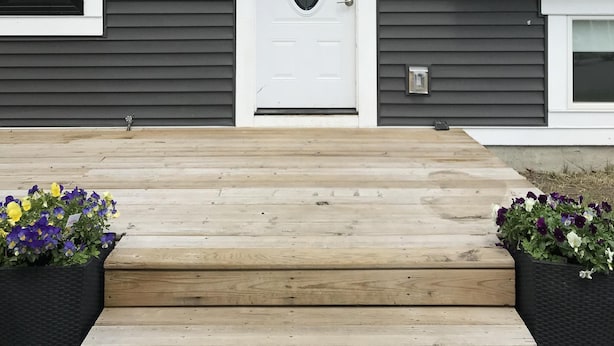 A residential house with a white front door, a mailbox, and a number '120' sign.