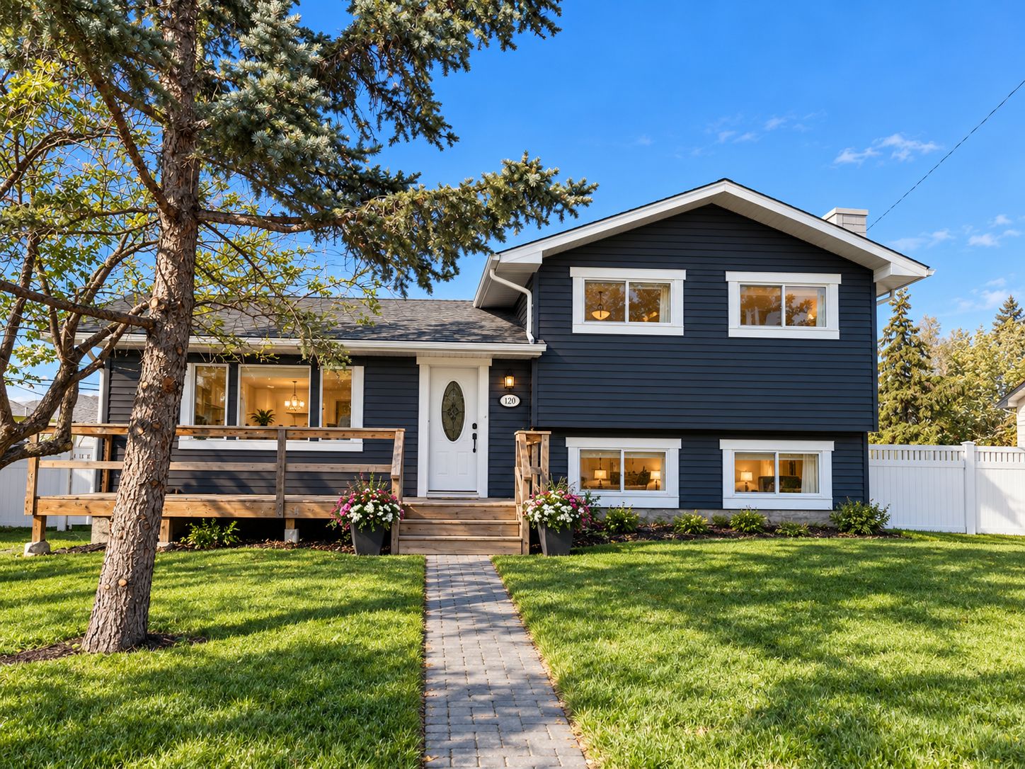 A two-story house with a front porch, a pathway leading to the door, and a well-maintained lawn.