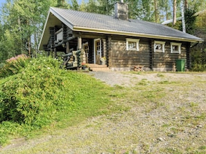 A log cabin with a porch, a chimney, and a gravel driveway. - Savilahti by Interhome (Juuka)
