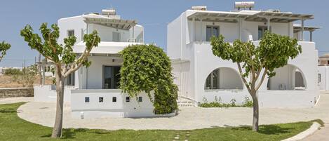 A modern white building with arched windows and a covered outdoor area.