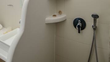 Un baño con bañera, ducha y ventana.