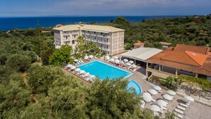 A hotel with a swimming pool, multiple balconies, and a view of the sea. - Hotel Zakynthos  (Zakynthos)
