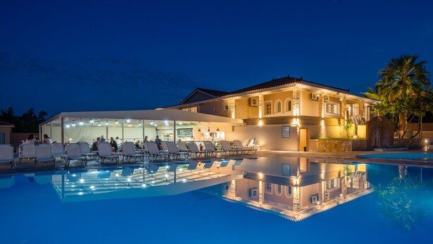 A hotel with a swimming pool, sun loungers, and a covered area with chairs. - Hotel Zakynthos  (Zakynthos)