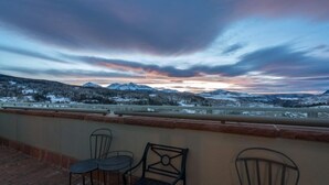 A terrace with a view of snow-covered mountains and a sunset. - Beautiful 2 Bedroom Penthouse in Mountain Village, CO (Mountain Village)
