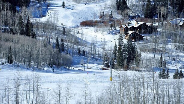 A snow-covered landscape with a lodge and ski trails. - Penthouse At The Peaks 614 (Mountain Village)