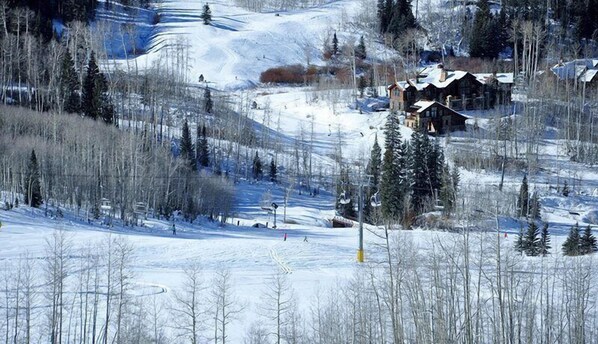 A snow-covered landscape with a lodge and ski trails. - Penthouse At The Peaks 614 (Mountain Village)