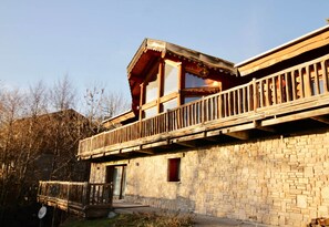 A two-story wooden building with a balcony, stone walls, and a small window. - Chalet Marmotte, 400m2 of comfort (Font-Romeu)