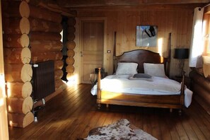 A log cabin bedroom with a wooden bed, a radiator, and a cowhide rug. - Chalet Marmotte, 400m2 of comfort (Font-Romeu)