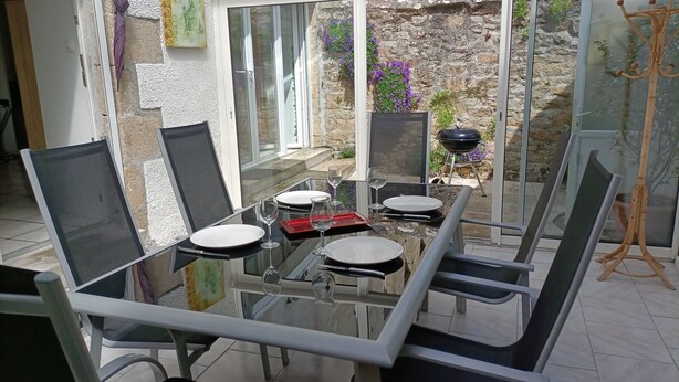 A glass dining table with chairs, a red tray, and wine glasses set for four. - Between Quimper and Douarnenez, 10 minutes from the beach (Plogastel-Saint-Germain)