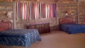 A bedroom with two beds, a wooden dresser, and a striped curtain. - Casa Baja, with panoramic view of the Sea of Cortez (San Felipe)