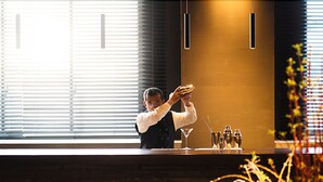 Zona de bar moderna con un bartender preparando bebidas.