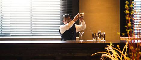 Uma área de bar moderna com um bartender preparando bebidas.